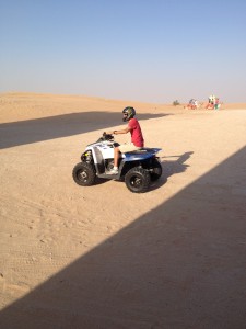 Dad riding a motorcycle-type thing in the desert.